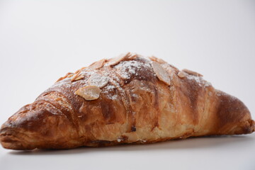 Traditional French breakfast croissant with almonds on white background