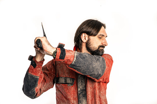 The man poses with an ax in a photo studio.