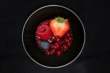beautiful and tasty looking cheesecake on a black background, covert with fruit, view from above