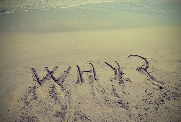 WHY written in the sand of the beach by the sea with question ma