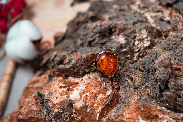 Bronze ring with a large amber stone on a wooden background
