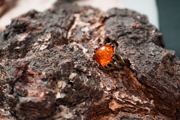 Bronze ring with a large amber stone on a wooden background
