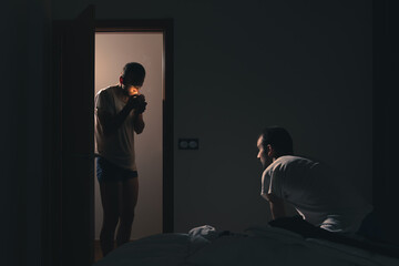 Depression, anxiety and mental health concept.  Depressed sad man in his bedroom sitting on the bed...