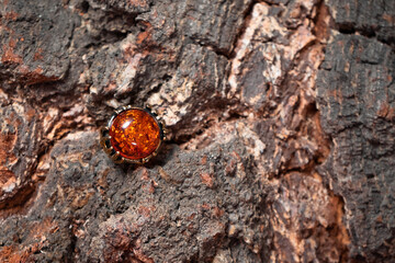 Bronze ring with a large amber stone on a wooden background
