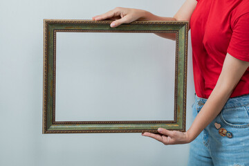 Young girl in red shirt holding a photo frame