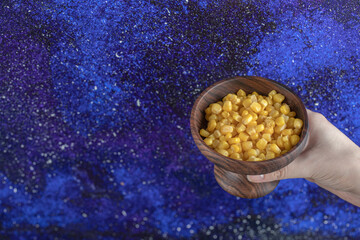Female hand holding Bowl Canned sweet corns