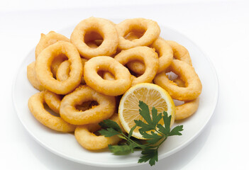 Anillas de calamar rebozadas con limon y perejil , vista cenital. Battered squid rings with lemon and parsley, overhead view.
