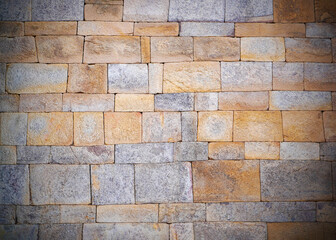 Old rusty stone wall with vignette effect ,vintage and antique style for background