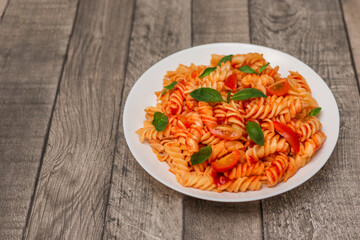 Italian pasta on plate on grey wooden background 