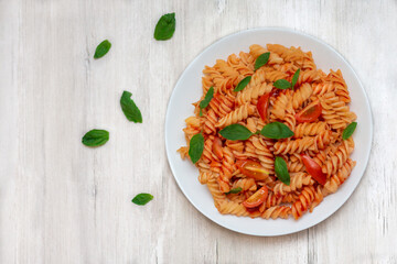 Italian pasta on plate on white wooden background 