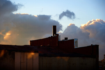 The roof of the old factory against the background of the sky and sunset.