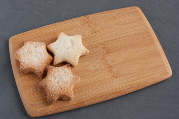 Delicious homemade cookies in the shape of stars sprinkled with sugar. Laid out on a kitchen board...