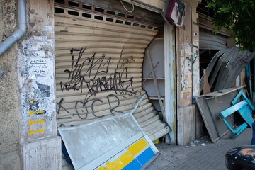 Fototapeta premium Metal shutter at a storefront in Beirut deformed from the shockwave of an explosion in August 2020