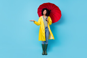 Photo of adorable sweet dark skin lady wear yellow overcoat walking holding red parasol arm feel...