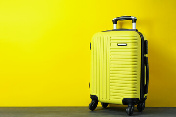 Travel bag on yellow background, space for text