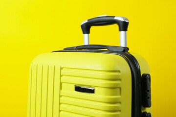 Travel bag on yellow background, close up