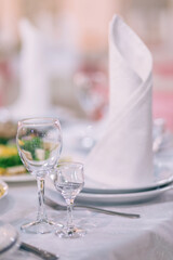 The restaurant has pink wedding tables, banquet, serving plates, glasses, fork and knife.