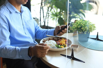 A business man have lunch and working by check smartphone in restaurant.