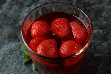 Glass of strawberry jelly on black smokey table
