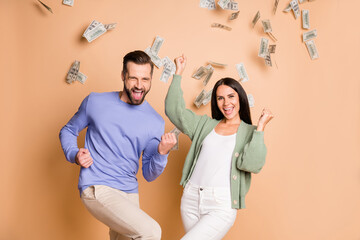 Photo of optimistic nice couple win money wear sweater pants isolated on beige color background