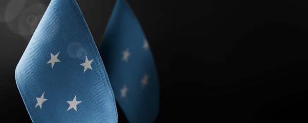 Small national flags of the Federated States Micronesia on a dark background