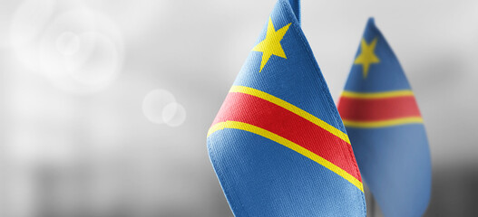 Small national flags of the Democratic Republic of the Congo on a light blurry background