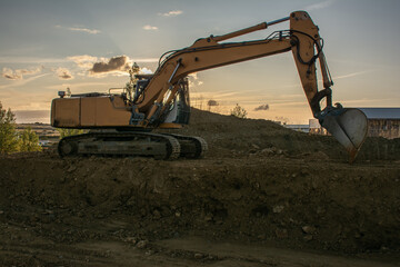 Excavator moving dirt and sand at a construction site