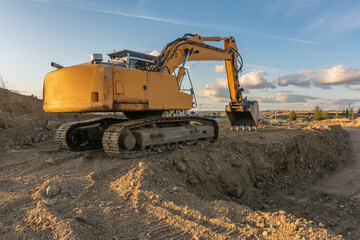 Obraz premium Excavator moving dirt and sand at a construction site