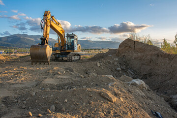 Excavator moving dirt and sand at a construction site