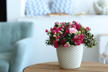 modern bedroom closeup fragment with flowers in vase, sofa and pillows on background