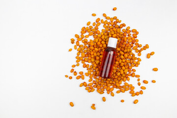 sea buckthorn oil in a transparent bottle with nuts on the background top view