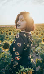 A beautiful young girl is looking at the camera dressed in her sunflower shirt