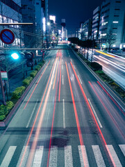 車のライトの光跡が光る都会の夜の道路