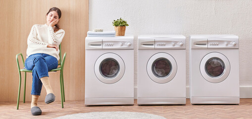 Laundry room washing machine and dirty clothes decorative modern style. Woman is waiting for the machine to finish.