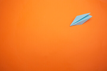 Fototapeta na wymiar light blue paper plane orange background