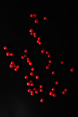 Frozen red currant berries scattered on a black background.