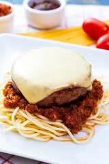 Cheese burger and spaghetti meat sauce homemade on the wooden table.