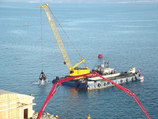 Excavator on a pontoon in the port of Split, Croatia