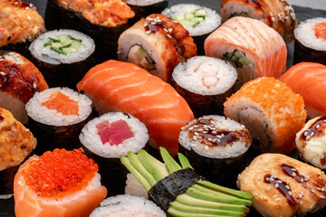 Assorted sushi nigiri and maki set on slate. A variety of Japanese sushi with tuna, crab, salmon,...