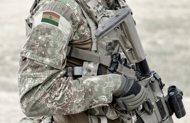 Soldier with assault rifle and flag of Bolivia on military uniform. Collage.