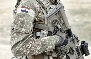 Soldier with assault rifle and flag of Paraguay on military uniform. Collage.