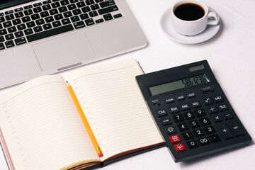 Calculator, open notebook, coffee cup and computer. Work desk of a company employee. Work at home or in the office. Accounting, analytics and banking. Business concept