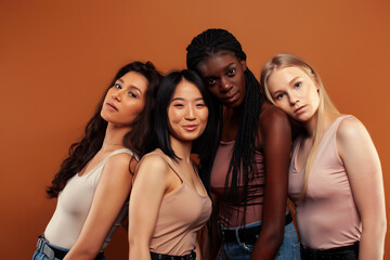 Fototapeta premium young pretty asian, caucasian, afro woman posing cheerful together on brown background, lifestyle diverse nationality people concept