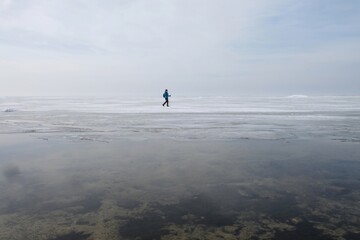 Silhouette of person with poles on horizon of sea with very calm water. Oslonino, Baltic Sea, Poland	
