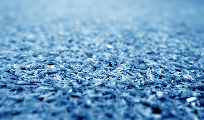 Obraz premium Blue color artificial grass close-up with blur background