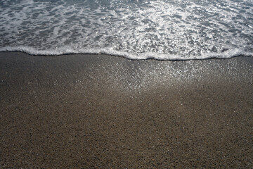Coming wave and beach sand.