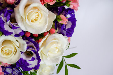 Background. Bouquet of flowers close-up on a white background. White and pink roses, blue-white eustoma. Place for text.