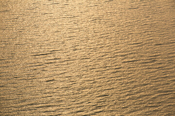 Golden tropical sea surface with waves and ripples