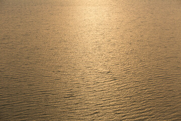 Golden tropical sea surface with waves and ripples