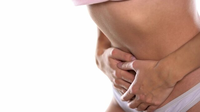 stomach cramps. a woman holding her stomach on a white background